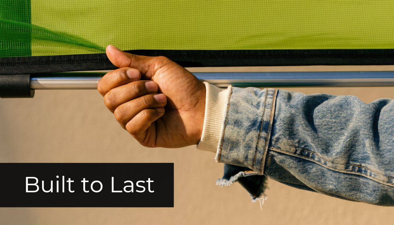 A hand pulling down a durable, lime green retractable pet screen door frame for easy access.