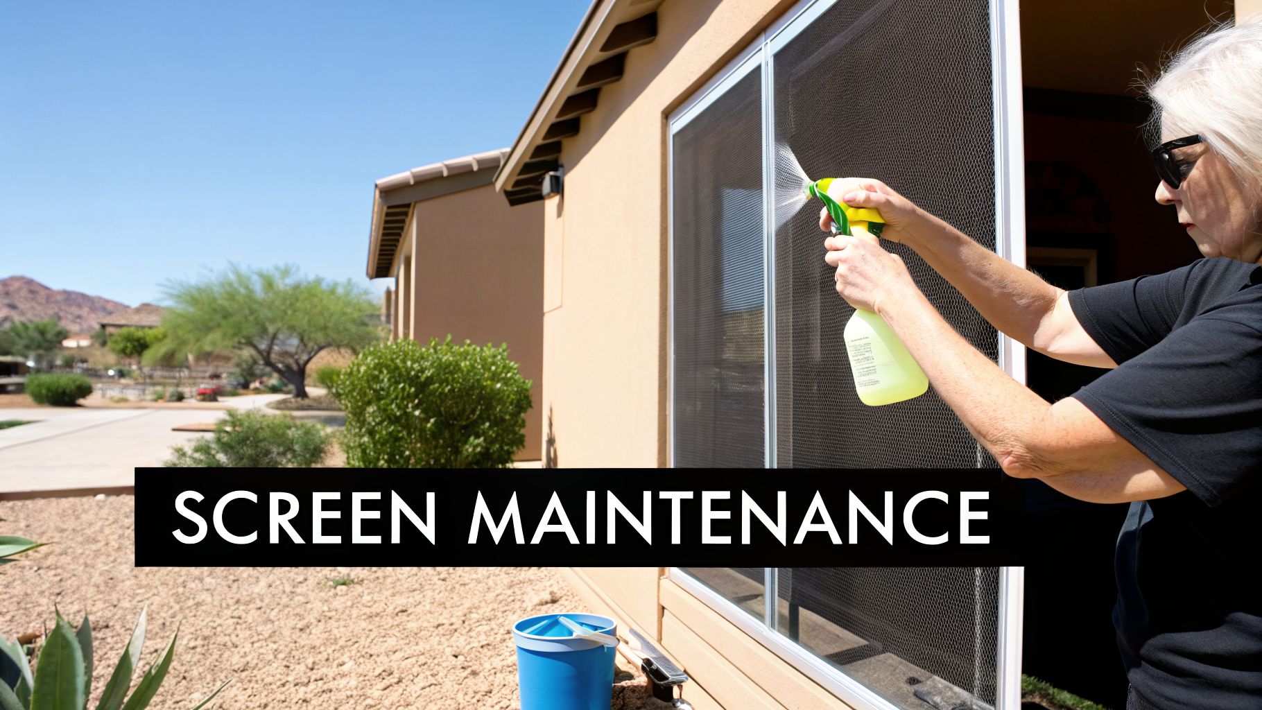 A person uses a spray bottle to clean a window screen on the side of a house.